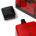 Maison Alhambra Narissa Ruby (Rouge) Maison Alhambra 100ml — A black cap rests next to a red perfume bottle and its box, set against a white background. | Maison Alhambra Narissa Ruby (Rouge) Maison Alhambra 100ml — Penutup hitam diletakkan di sebelah botol minyak wangi merah dan kotaknya, berlatarkan putih.