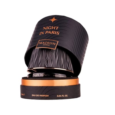 Maison Asrar Night In Paris by Maison Asrar 90ml EDP Unisex — Black textured cylindrical box with gold accents, open to reveal the perfume bottle with a ridged black cap and gold trim.