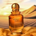 Khadlaj Ombre Notes by Khadlaj 100ml EDP Unisex — Amber glass perfume bottle with a textured gold cap, set against a desert landscape at sunset.
