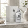 Zimaya Oscar Platinum by Zimaya 100ml EDP Unisex — Botol minyak wangi perak dan kotaknya yang bertekstur putih dipamerkan di atas meja marmar dengan pasu dan tumbuhan di latar belakang.