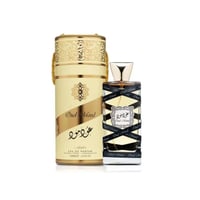 Lattafa Oud Mood Lattafa Arabian 100ml EDP — A tall, cylindrical gold and cream patterned box stands next to a clear glass perfume bottle with a gold cap and black ribbon detail.