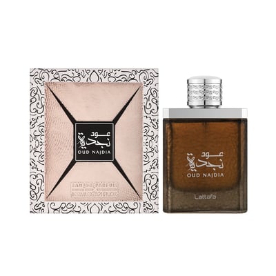 Lattafa Oud Najdia — A rose gold textured box with ornate black and white patterns sits next to a clear glass bottle of brown perfume with a silver patterned cap.