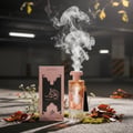 Afnan Supremacy Collector’s Edition — Exploding perfume bottle with lemon, apple slices, leaves, and glass shards flying out.