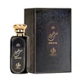 Afnan Supremacy Incense by Afnan Perfumes — Two hands hold a dark blue glass perfume bottle with a silver ring cap and