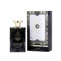 Al Wataniah Alexandrite Nawal — Black glass perfume bottle with gold cap next to its dark grey and gold box on a white
