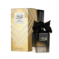 Ard Al Zaafaran Bint Hooran — Black glass perfume bottle with black bow and gold cap, next to gold patterned box.