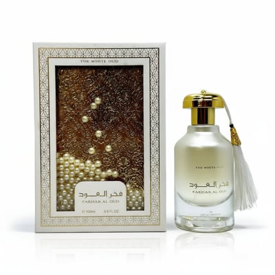 Ard Al Zaafaran Fakhar Al Oud “The White Oud” — White bottle with gold cap and tassel next to ornate box with pearls and