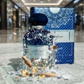 Ard Al Zaafaran Jazzab Silver – Silver bottle with geometric pattern, surrounded by golden flames on a cracked black