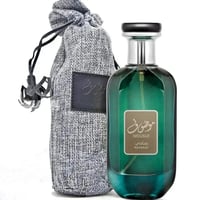 Ard Al Zaafaran Mousuf Ramadi — Green glass perfume bottle next to a grey textured drawstring pouch with a leather patch