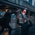 Ard Al Zaafaran Dar Al Hae — Man in suit holding perfume bottle in rain at night