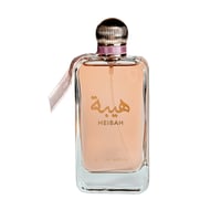Ard Al Zaafaran Heibah — Rectangular glass perfume bottle with peach liquid, gold cap, pink ribbon, and Arabic script.