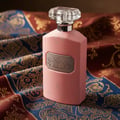 Ard Al Zaafaran Ajmal Ehsas Bloom — Pink perfume bottle and box on a car dashboard at night with city lights blurred in