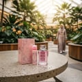 Ard Al Zaafaran Hooria for Her — Pink duffel bag with white towel and perfume bottle next to a purple and silver box.