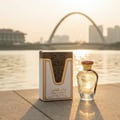 Ard Al Zaafaran Mousuf — Broken glass perfume bottle with amber liquid spilling and smoke rising