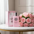Al Wataniah Shagaf Al Ward — Pink rose patterned box next to a faceted glass perfume bottle with a black tassel.