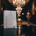Al Wataniah Special Oud — Amber liquid in a clear glass bottle with a textured gold cap, set against a blurred warm yellow
