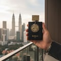 Ard Al Zaafaran Thara Al Oud — Black cylinder box with gold band next to glass perfume bottle with gold accents and smoke