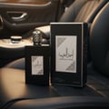 Armaf Monarque by Armaf Lions Club 100ml EDP — Gold lion head bottle in orange box inside car dashboard with skyscrapers