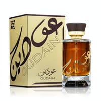 Lattafa Oudain oleh Lattafa Perfumes 100ml EDP untuk Lelaki — Kotak emas dengan kaligrafi Arab dan teks 'OUDAIN', bersama botol minyak wangi kaca berisi cecair perang dan penutup coklat gelap.