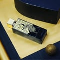 Perfume bottle with decorative packaging on a textured surface