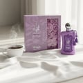 Lattafa Ajayeb Dubai Portrait EDP — White box with gold accents next to a glass perfume bottle with yellow liquid and fruit