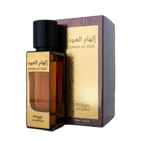 Zimaya Ilham Al Oud EDP Unisex — Botol minyak wangi kaca perang dengan penutup hitam dan label emas, bersebelahan kotak bertekstur coklat dan emasnya.