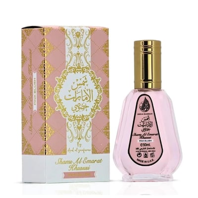 Ard Al Zaafaran Pink Blush Shams Al Emarat Khususi 50ml — Pink perfume bottle with gold cap next to its pink and gold patterned box, both featuring Arabic calligraphy.