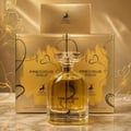 Maison Alhambra Precious Gold 80ml — A clear glass perfume bottle with golden liquid and a clear faceted cap, placed in front of two gold boxes with black abstract designs and a deer logo. | Maison Alhambra Precious Gold 80ml — Botol minyak wangi kaca jernih dengan cecair keemasan dan penutup faset jernih, diletakkan