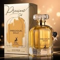 Maison Alhambra Precious Gold 80ml — A gold-colored perfume bottle with a faceted crystal cap and a black heart charm, standing next to its matching gold box with a deer silhouette. | Maison Alhambra Precious Gold 80ml — Botol minyak wangi berwarna emas dengan penutup kristal berfacets dan loket hati hitam, berdiri di