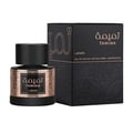 Lattafa Tamima — Black textured box with gold Arabic calligraphy and text 'TAMIMA' and 'Lattafa', next to a black bottle with a wooden cap and a rose gold textured label with Arabic calligraphy and text 'TAMIMA' and 'Lattafa' | Lattafa Tamima — Kotak bertekstur hitam dengan kaligrafi Arab emas dan teks 'TAMIMA' dan