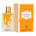 Maison Alhambra Sugar Me Carrot Cake EDP — Clear glass perfume bottle with orange dripping design and gold cap, next to its orange and white striped box.