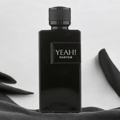 Maison Alhambra Yeah! Parfum Man by Maison Alhambra 100ml EDP — Black rectangular perfume bottle with a black cap, featuring 'YEAH! PARFUM' text on the front, set against a white background with draped black fabric.