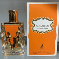Maison Alhambra Sugar Me Carrot Cake — Clear glass perfume bottle with gold cap and orange decorative elements, next to its orange and white product box.