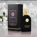 Maison Alhambra Philos Opus Noir — Black perfume bottle with gold accents and a matching patterned box, set against a soft floral background.