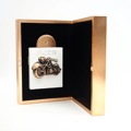 Lattafa Pride La Collection d'Antiquites 1910 (Bike) by Lattafa Pride 100ml — White perfume bottle with a copper motorcycle emblem and cap, presented in an open rose gold box lined with black velvet.