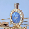 Lattafa Victoria by Lattafa 100ml EDP — Gold fluted perfume bottle with blue marbled insert, on a gold tray with gold butterfly and chain necklace