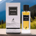 Maison Alhambra Winsome by Maison Alhambra 90ml EDP — White box with black text and deer logo next to a clear glass perfume bottle with gold liquid and black cap, set against a blurred mountain and forest background.