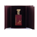 Ard Al Zaafaran Ahlam Al Khaleej 80ml — Botol minyak wangi merah maroon dengan penutup emas bertekstur, diletakkan dalam kotak hadiah terbuka berwarna merah maroon dengan latar belakang hitam.