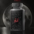 Zimaya Al Embratur Absolu Eau De Parfum 100ml by Zimaya — Black perfume bottle with ornate Arabic script in red, set against a large, textured moon in the background. | Zimaya Al Embratur Absolu Eau De Parfum 100ml by Zimaya — Botol minyak wangi hitam dengan skrip Arab berornamen berwarna merah, berlatar belakang