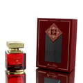 Al Wataniah Al Wataniah Rawaee Monarch Eau De Parfum 100ml — A red glass perfume bottle with a gold cap sits to the left of its matching red and gold presentation box with a window. | Al Wataniah Al Wataniah Rawaee Monarch Eau De Parfum 100ml — Botol kaca merah dengan penutup emas duduk di sebelah kiri kotak