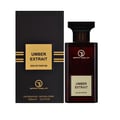Grandeur Umber Extrait Eau de Parfum — A dark brown glass perfume bottle with a gold label and a black cap stands next to its matching black and gold patterned box, both featuring the Grandeur logo and product name. | Grandeur Umber Extrait Eau de Parfum — Botol kaca coklat gelap dengan label emas dan penutup hitam