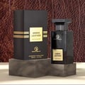Grandeur Amber Leather 100ml by Grandeur Perfumes — A black perfume box and bottle are displayed on dark grey marble stands against a textured brown leather background. | Kotak dan botol minyak wangi hitam Grandeur Amber Leather 100ml dipamerkan di atas tapak marmar kelabu gelap berlatarkan latar belakang kulit coklat