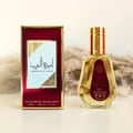 Ard Al Zaafaran Ameerat Al Arab Princess of Arabia 50ml — Kotak hadiah merah berbingkai emas di sebelah kiri, botol kaca lutsinar berisi cecair keemasan dengan penutup emas di sebelah kanan, latar belakang berbulu lembut.