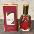 Ard Al Zaafaran Ameerat Al Arab Princess of Arabia 50ml — Kotak wangi berwarna merah jambu dengan tulisan Arab dan emas, bersebelahan dengan botol kaca lutsinar berisi cecair merah jambu dan penutup emas.