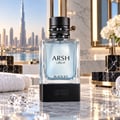 French Avenue Arsh Black Ice — A clear glass perfume bottle with light blue liquid, black studded cap, and gold accent, displayed on a black base with the brand name. Background shows a city skyline with skyscrapers and water.
