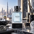 French Avenue Arsh Black Ice — Clear glass perfume bottle with black studded cap, set on a black base, with a Dubai cityscape visible through a window in the background.