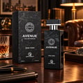 Grandeur Avenue New York oleh Grandeur 100ml EDP Lelaki — Kotak dan botol wangian lelaki corak marmar hitam, bersama gelas wiski dan pen di atas meja kayu.