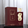 Lattafa Pride Ansaam Gold by Lattafa Pride 100ml EDP — A maroon box and bottle of Lattafa Pride Ansaam Gold perfume, with gold floral accents on the bottle and gold text on the box.