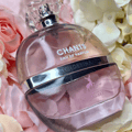 Maison Alhambra Chants Tenderina by Maison Alhambra 100ml EDP — A clear glass perfume bottle with pink liquid, featuring white text 'CHANTS EAU DE PARFUM TENDERINA' and a pink deer logo, set against a soft background of pink and cream roses.