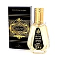 Ard Al Zaafaran Badee Al Oud Eau De Parfum 50ml — A black and gold patterned box stands next to a clear glass perfume bottle with a gold cap and a black label featuring Arabic and English text. | Ard Al Zaafaran Badee Al Oud Eau De Parfum 50ml — Kotak bercorak hitam dan emas berdiri di sebelah botol minyak wangi kaca